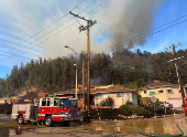 Firefighters work to stop a fire that damaged homes, in Oakland