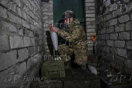 Policeman of the 'Khyzhak' Brigade prepares mortar shells before firing towards Russian troops at their position in a front line near the town of Toretsk