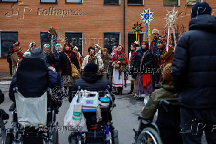 People dressed in traditional clothes sing carols for injured service members in Kyiv