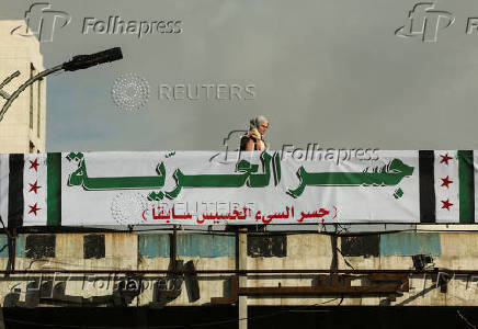 A woman walks on formerly named ''President's Bridge'', in Damascus