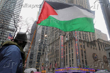 A demnostrator holds a Palestinian flag near Radio City Music Hall in Manhattan