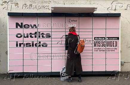 FILE PHOTO: A woman stands at an InPost locker in Hackney, London