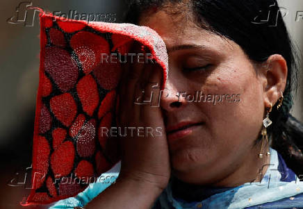 Woman wipes her face on a hot day in Mumbai