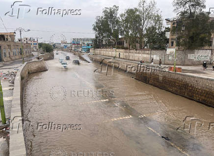 Vehicles drive on flooded road following rains in Sanaa