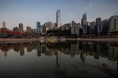 FILE PHOTO: The city skyline is reflected in a pool left on the dry riverbed of the receding Jialing river, a tributary of the Yangtze, that is approaching record-low water levels during a regional drought in Chongqing