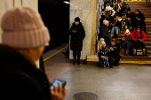 People take shelter inside a metro station during a Russian military strike, in Kyiv