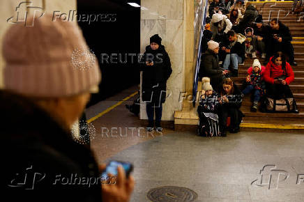 People take shelter inside a metro station during a Russian military strike, in Kyiv