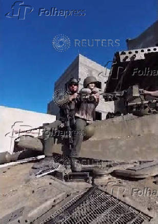 An Israeli soldier sits on top of a tank holding a female mannequin in a screengrab of a video