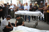 Mourners react next to the bodies of Palestinians killed in Israeli strikes, in Rafah