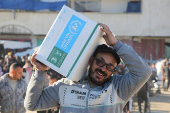 Palestinians receive aid following a ceasefire between Israel and Hamas, in Khan Younis in the southern Gaza Strip