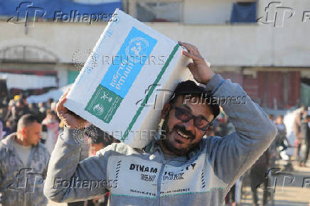 Palestinians receive aid following a ceasefire between Israel and Hamas, in Khan Younis in the southern Gaza Strip