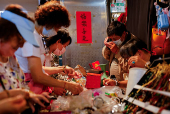 People look at products in a stall at a market in Taipei