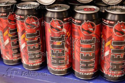 Cans of Hell Energy Drink are displayed on a shelf in a supermarket