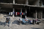 A street vendor sells clothes at al-Yarmouk Palestinian refugee camp in Damascus