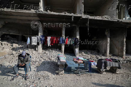 A street vendor sells clothes at al-Yarmouk Palestinian refugee camp in Damascus