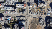 A drone view shows damaged and destroyed buildings as displaced Palestinians shelter in tents, following a ceasefire between Israel and Hamas, in Gaza City