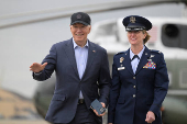 U.S. President Joe Biden waves while walking with Commander of the 89th Airlift Wing Andrea Ochoa, at Joint Base Andrews
