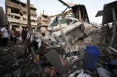 Palestinians gather at a UN school sheltering displaced people, following an Israeli strike, amid Israel-Hamas conflict, in Gaza City