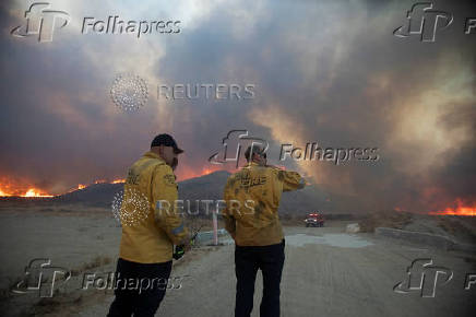 Firefighters and aircraft battle the Hughes Fire near Santa Clarita