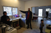 A resident of Baalbek, Abbas Wehbe, gestures as he stands with family members inside his kitchen in Baalbek