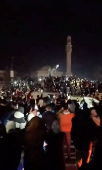 People cheer as the statue of former President of Syria Hafez al-Assad is toppled in Homs