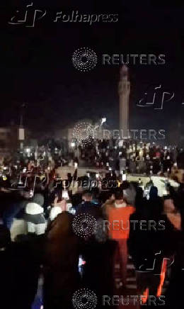 People cheer as the statue of former President of Syria Hafez al-Assad is toppled in Homs