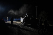 Israeli soldiers walk near a military vehicle after returning from Lebanon, following a ceasefire between Israel and Iran-backed group Hezbollah, near Kiryat Shmona