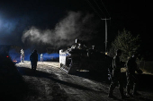 Israeli soldiers walk near a military vehicle after returning from Lebanon, following a ceasefire between Israel and Iran-backed group Hezbollah, near Kiryat Shmona