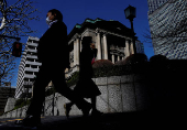 FILE PHOTO: Pedestrians walk past the Bank of Japan building in Tokyo