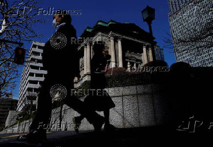 FILE PHOTO: Pedestrians walk past the Bank of Japan building in Tokyo