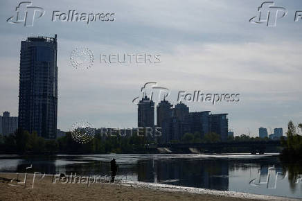 Man fishes on a public beach in Kyiv