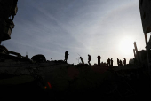 Palestinians inspect damage at the site of an Israeli strike on a house, at Nuseirat refugee camp