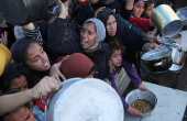 Palestinians gather to receive food cooked by a charity kitchen, in Khan Younis