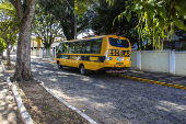nibus para transporte de estudantes estacionado na frente de uma escola estadual