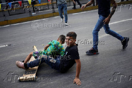 Government supporters participate in a traditional street race with wooden makeshift carts called 