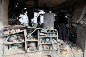 Palestinians inspect the site of an Israeli strike on a house, in Rafah, in the southern Gaza Strip