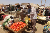 FILE PHOTO: A man buys vegetables from a local vendor during the month of Ramadan in the city of Omdurman