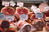Cured meat products made with pork are displayed at a market stall in Rome