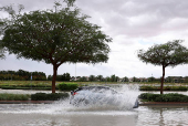 Car drives through water in a flooded street following heavy rains in Dubai