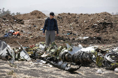 FILE PHOTO: American civil aviation and Boeing investigators search through the debris at the scene of the Ethiopian Airlines Flight ET 302 plane crash, near the town of Bishoftu, southeast of Addis Ababa