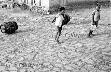 1959Criana puxa barril em cidade na