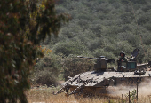 Israeli soldiers sit in a military vehicle near Israel's border with Gaza