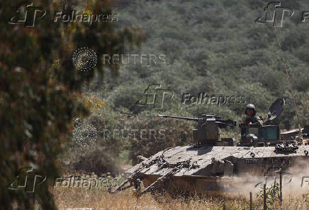 Israeli soldiers sit in a military vehicle near Israel's border with Gaza
