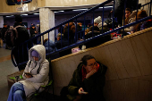 People take shelter inside a metro station during a Russian military strike, in Kyiv