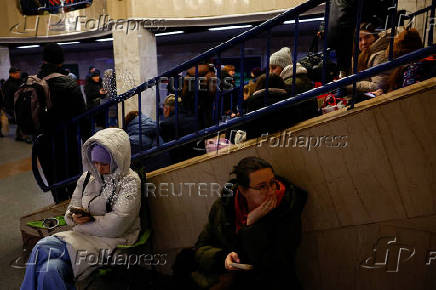 People take shelter inside a metro station during a Russian military strike, in Kyiv