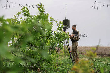 Ukrainian serviceman sets up an antenna before using a reconnaissance UAV in a front line in Donetsk region