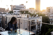 Einav Zangauker, mother of Israeli hostage Matan Zangauker who was seized by Hamas on October 7 and remains in Gaza, speaks on the phone as she sits on her balcony in Tel Aviv