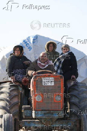 Displaced people who fled from Aleppo countryside, ride on a vehicle in Tabqa