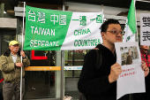 Protesters holding flags supporting Taiwan's independence stand outside the Songshan Airport while Shanghai Vice Mayor Hua Yuan arrives for the annual city forum in Taipei