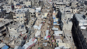 A drone view shows Palestinians walking at a street market, in Khan Younis